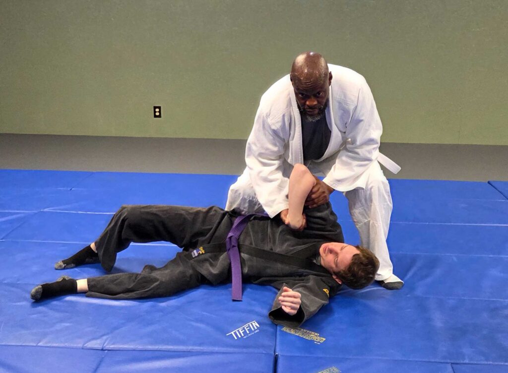Adult students practicing jujitsu techniques during class